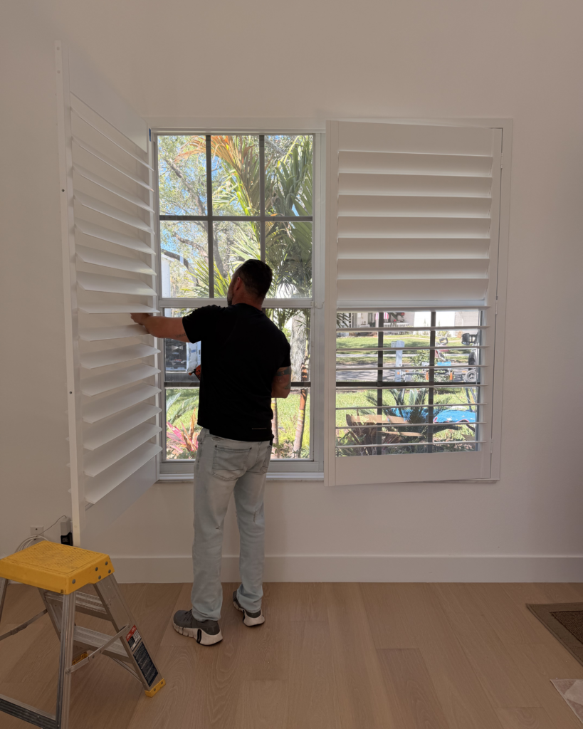 Plantation shutter installation on bedroom window by Plantation Shutters & Design in Palm Beach Gardens